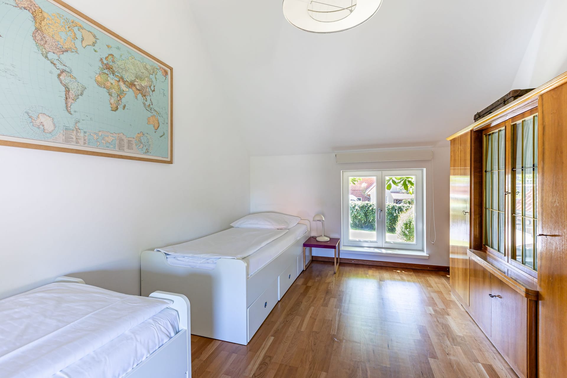 Schlafzimmer mit zwei Einzelbetten und Kartenwandgestaltung.