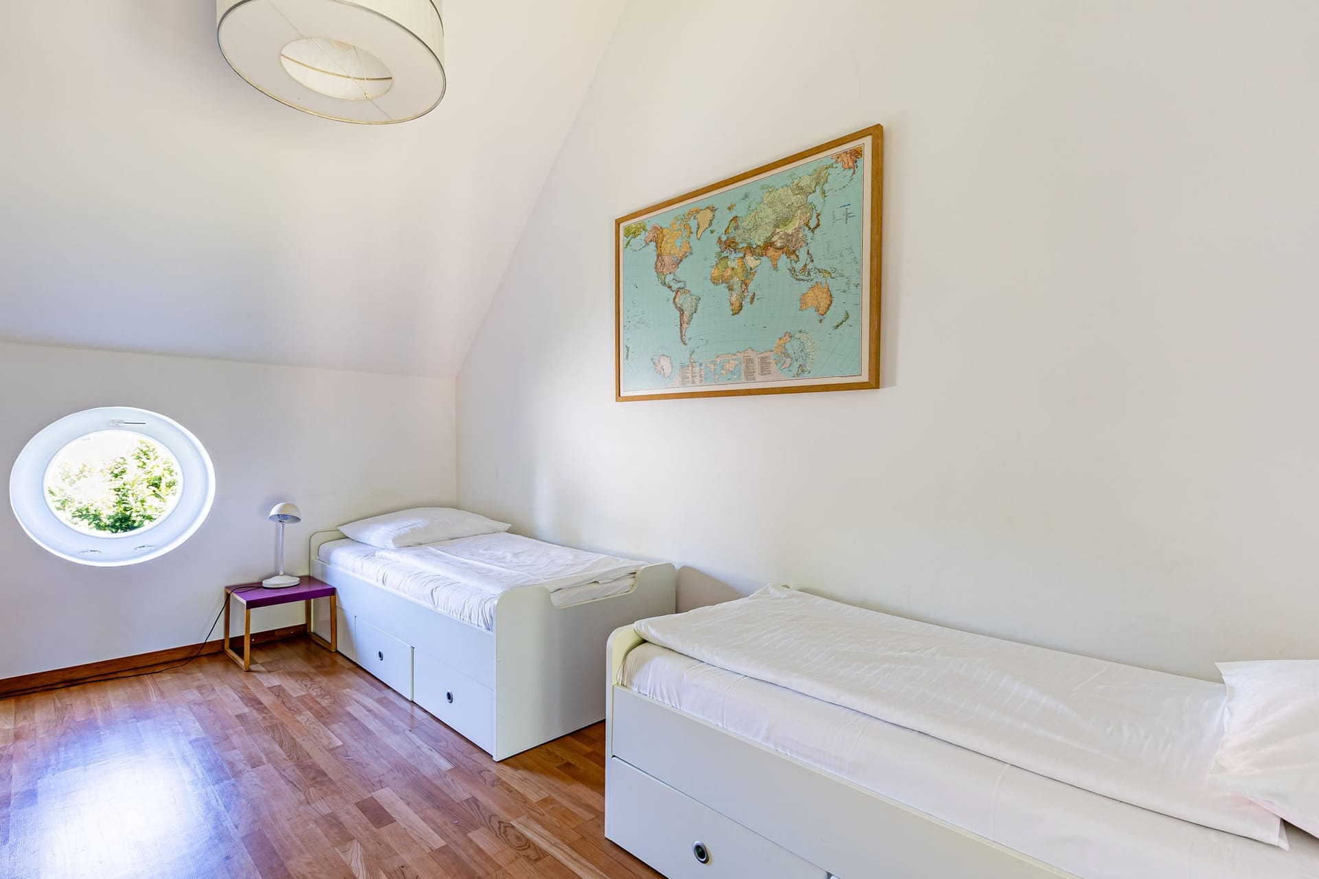 Schlafzimmer mit zwei Einzelbetten und Weltkarte