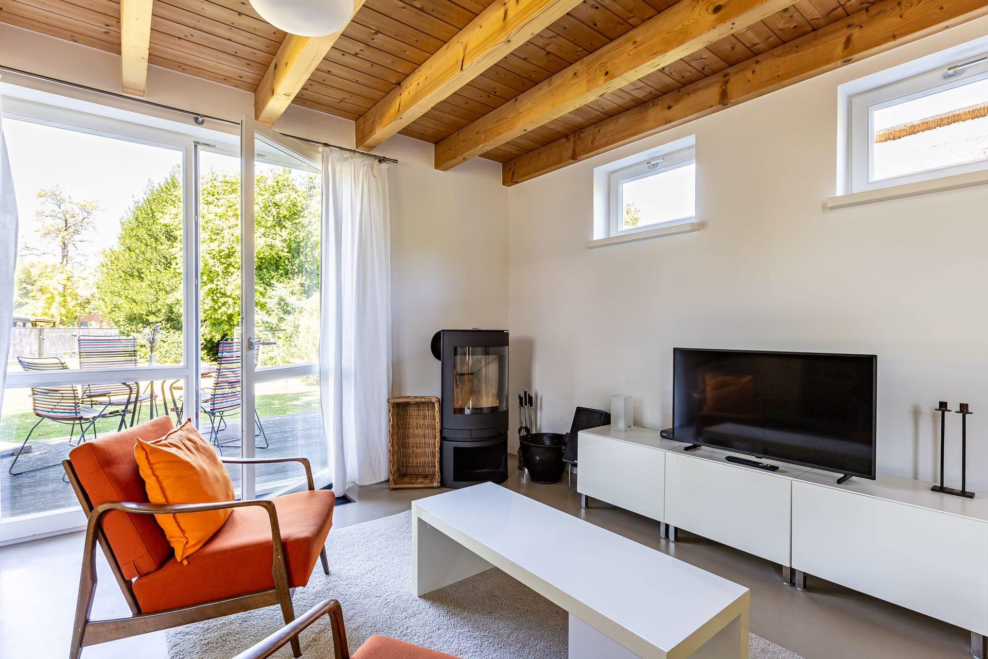 Helles Wohnzimmer mit Fernseher und Sofa