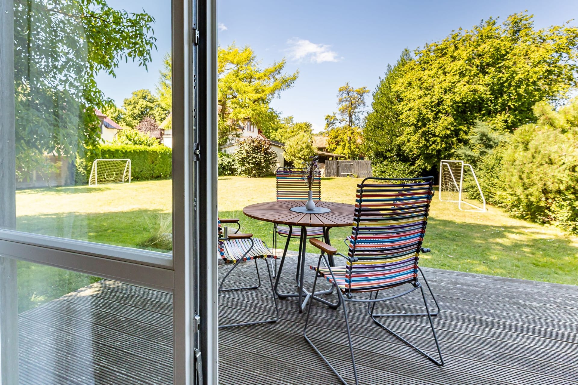 Terrasse mit Tisch und bunten Stühlen