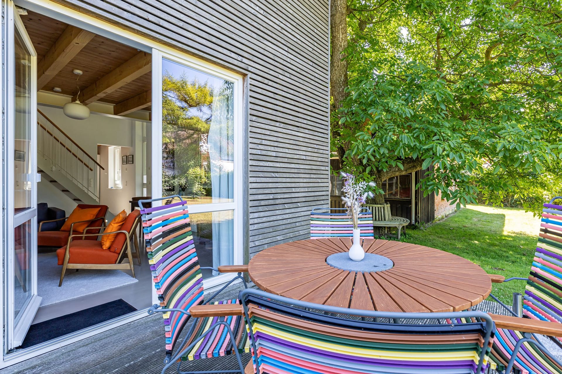 Terrasse mit Tisch und bunten Stühlen