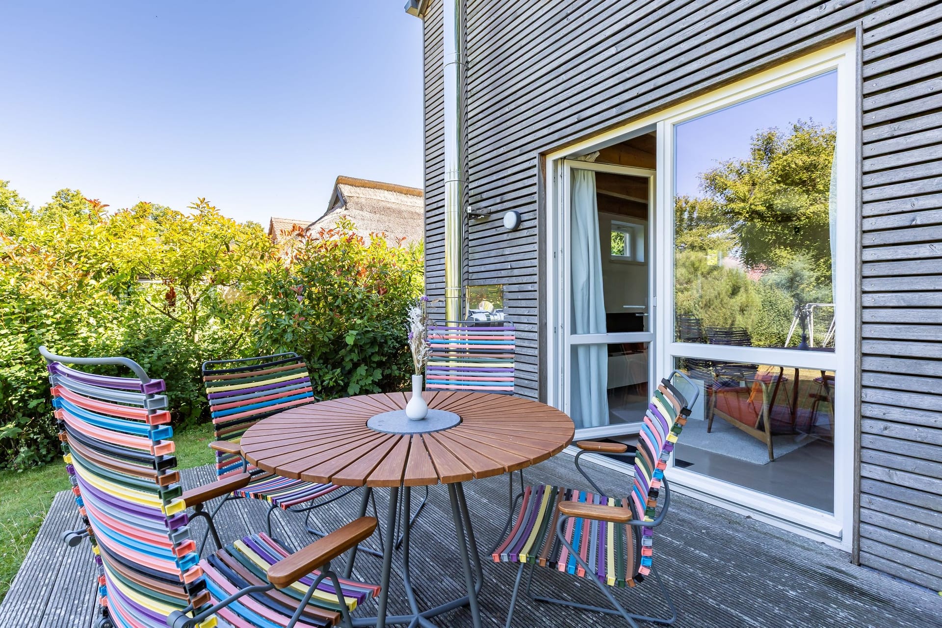 Terrasse mit Tisch und bunten Stühlen