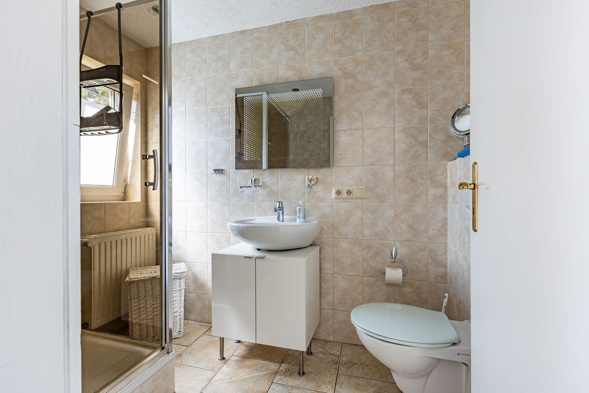 Badezimmer mit Dusche und Waschbecken