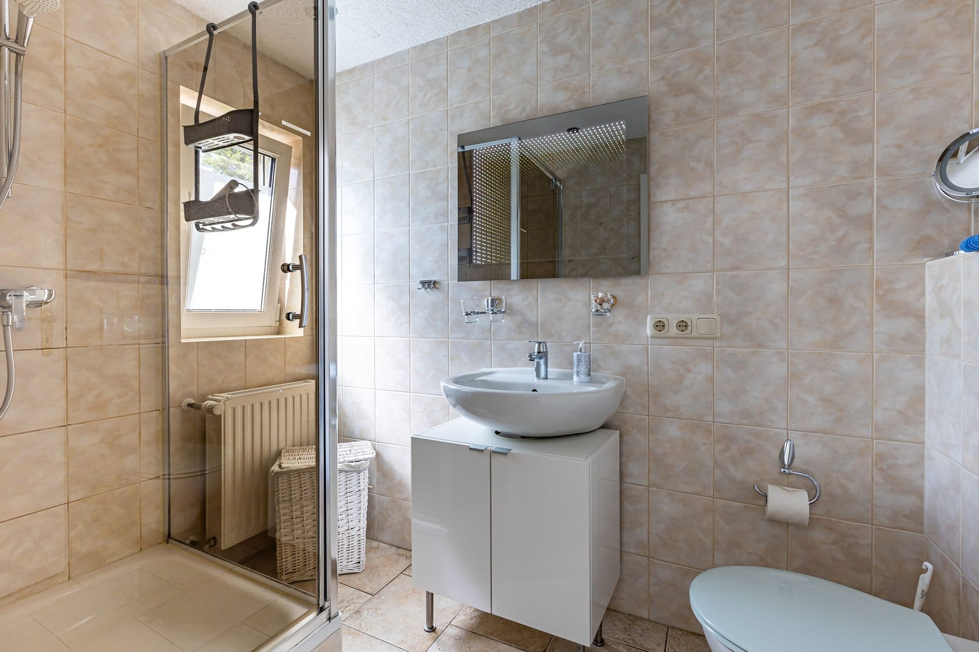 Badezimmer mit Dusche und modernem Waschbecken