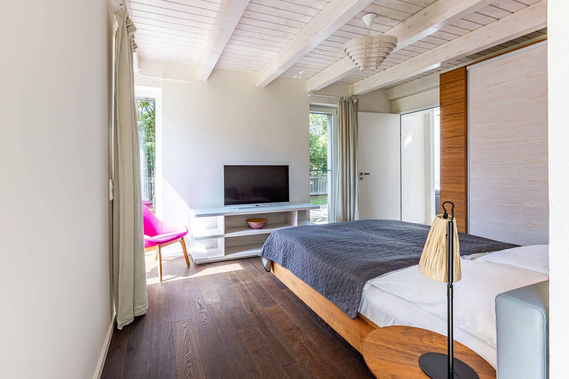 Schlafzimmer mit Fernseher und Fenster
