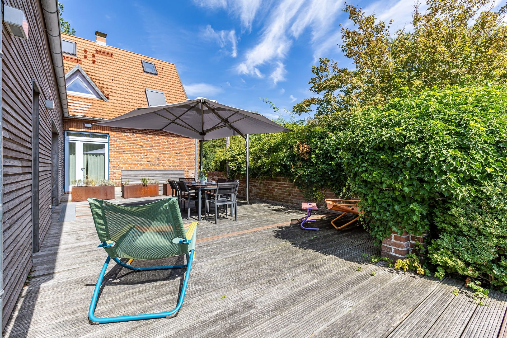 Terrasse mit Tisch und Sonnenschirm