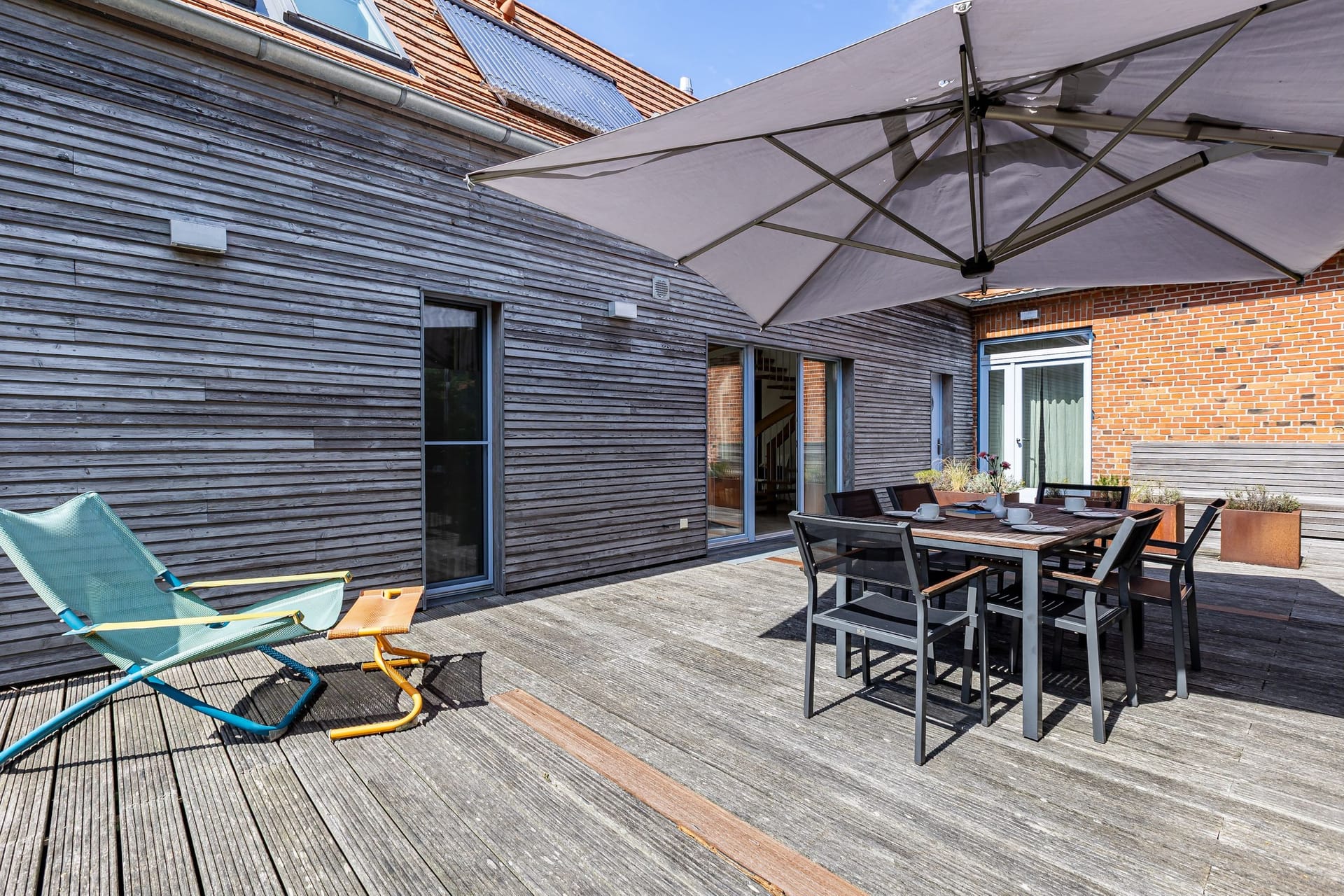 Terrasse mit Tisch und Sonnenschirm