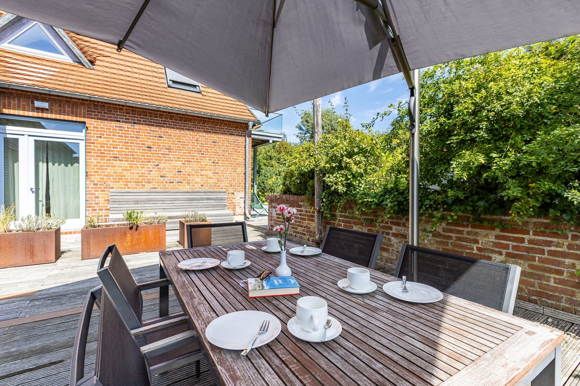 Terrasse mit Tisch und Sonnenschirm