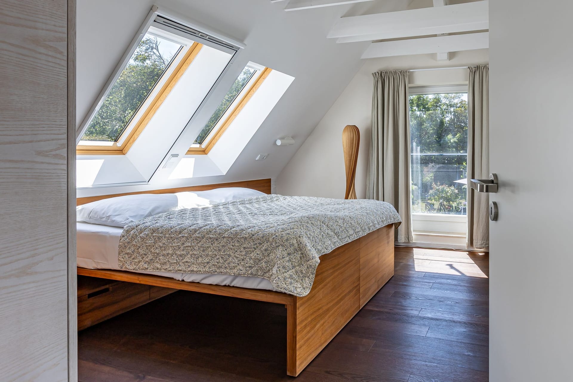 Schlafzimmer mit Dachfenstern und Zugang zum Balkon
