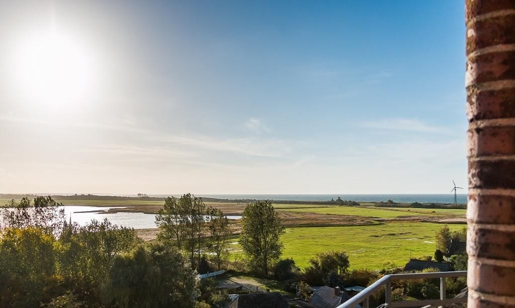 Weitläufige Landschaft mit Wasser und Windrädern