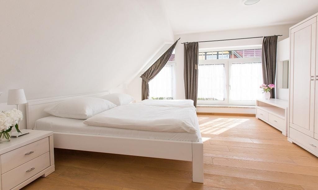 Helles Schlafzimmer mit Doppelbett und Fenster