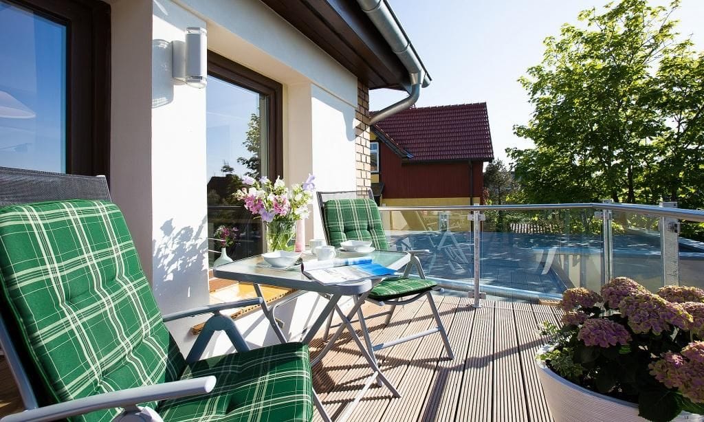 Balkon mit Stühlen und Tisch in sonniger Lage.