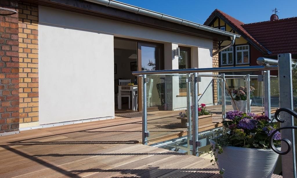 Terrasse mit Holzbelag und Glasgeländer