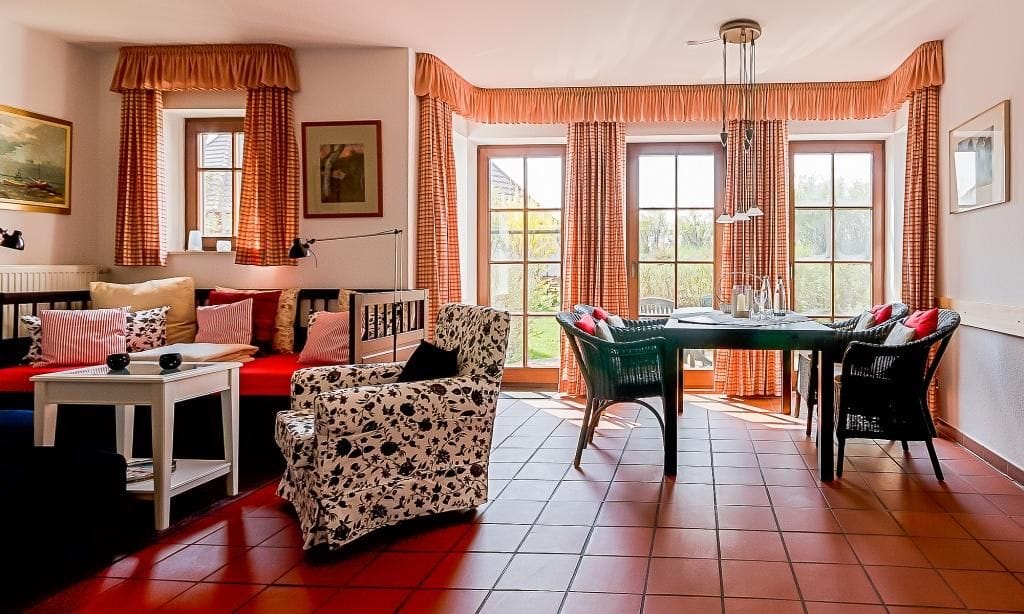 Helles Wohnzimmer mit Esstisch und gemütlichen Sitzen.