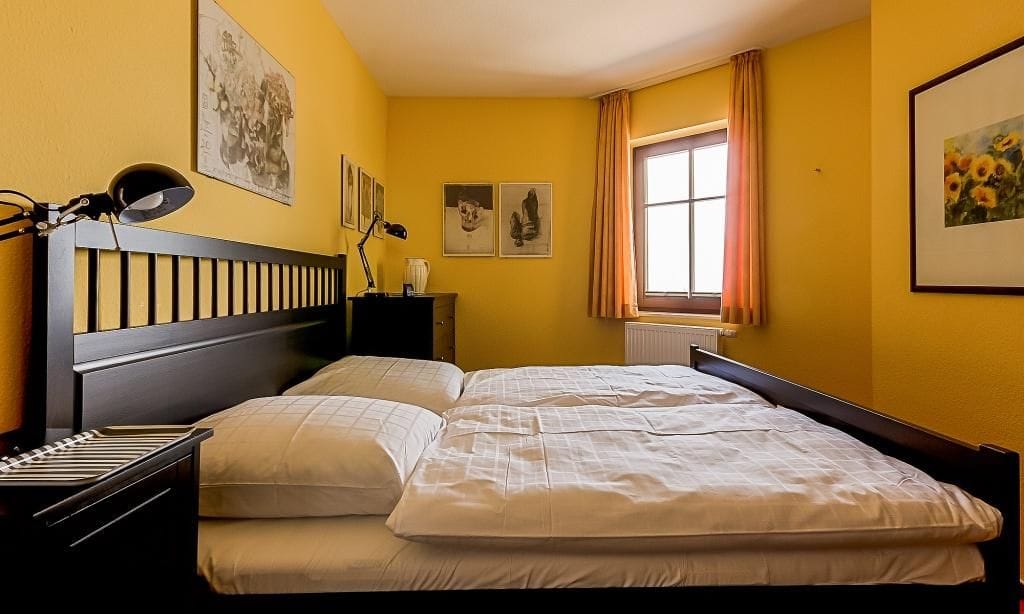 Helles Schlafzimmer mit Doppelbett und Fenster