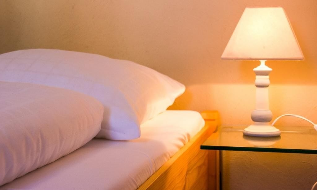 Schlafzimmer mit Bett und Nachttischlampe