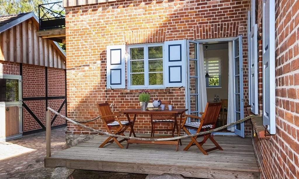 Terrasse mit Tisch und Holzstühlen