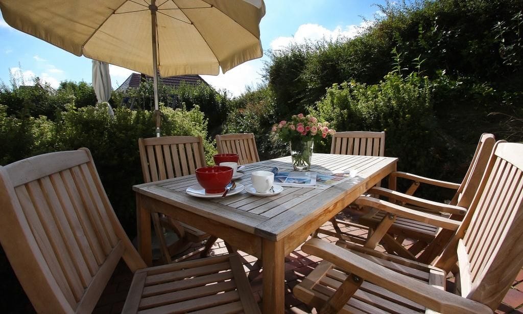 Terrasse mit Holztisch und Sonnenschirm
