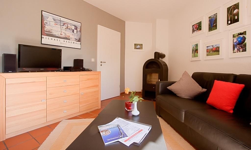 Gemütliches Wohnzimmer mit Ofen und Fernseher