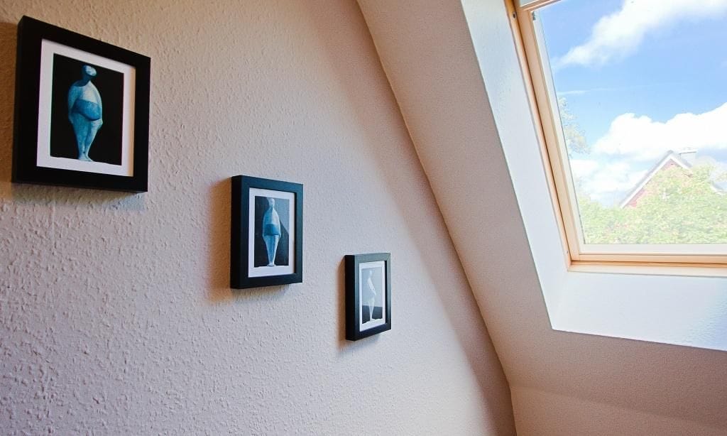 Wand mit Bildern und Dachfenster