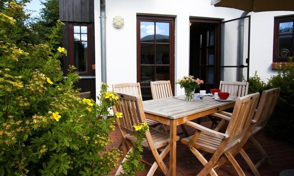 Gemütliche Terrasse mit Holztisch und Stühlen