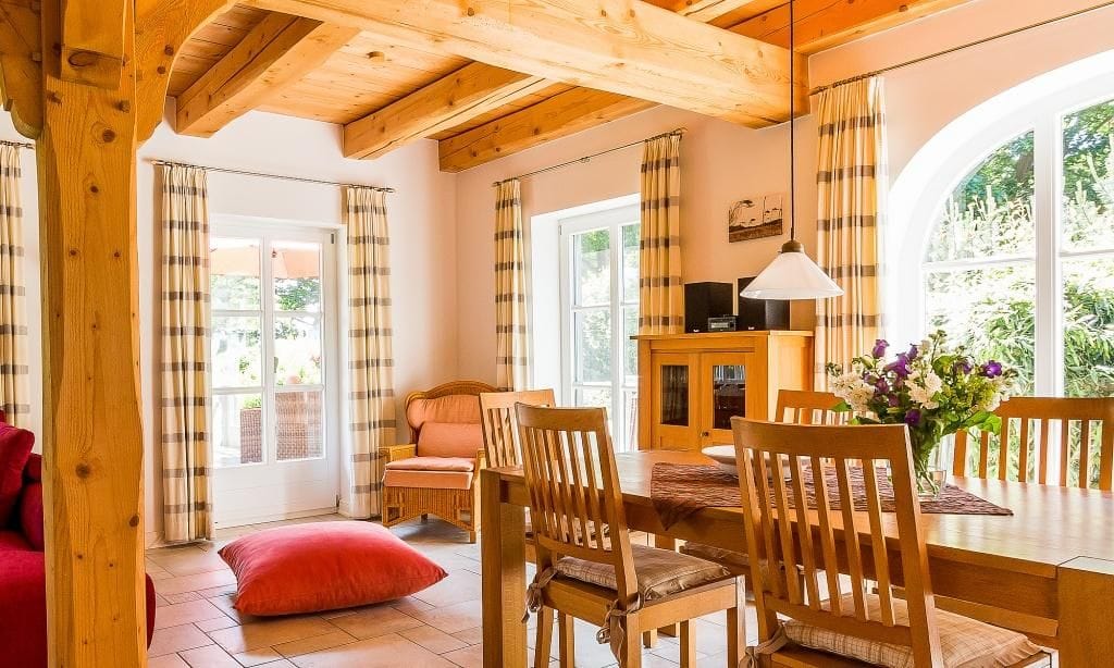 Helles Wohnzimmer mit Esstisch und gemütlichen Sitzgelegenheiten.