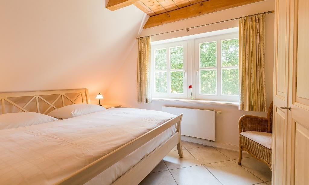 Helles Schlafzimmer mit Doppelbett und Stuhl