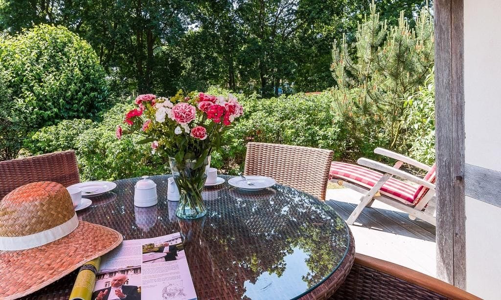 Terrasse mit Tisch und Blumenarrangement