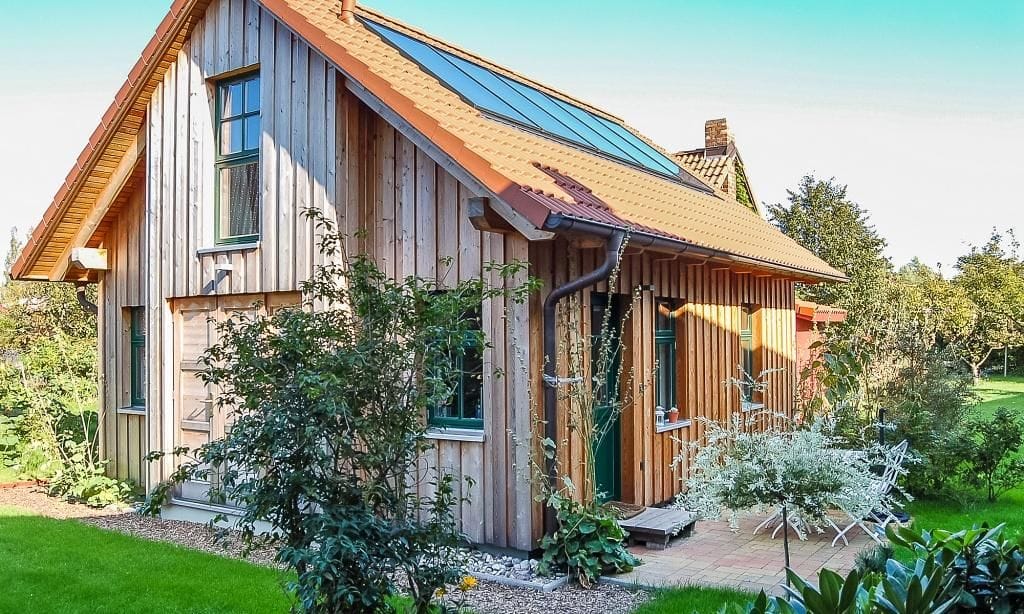 Außenansicht eines Holzhauses mit Garten