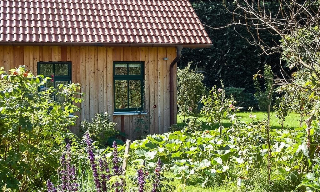 Außenansicht eines Holzhauses mit Garten