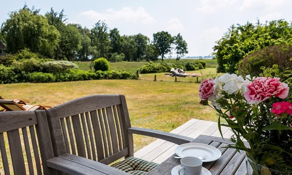 Terrasse mit Holzstuhl und Blumenblick