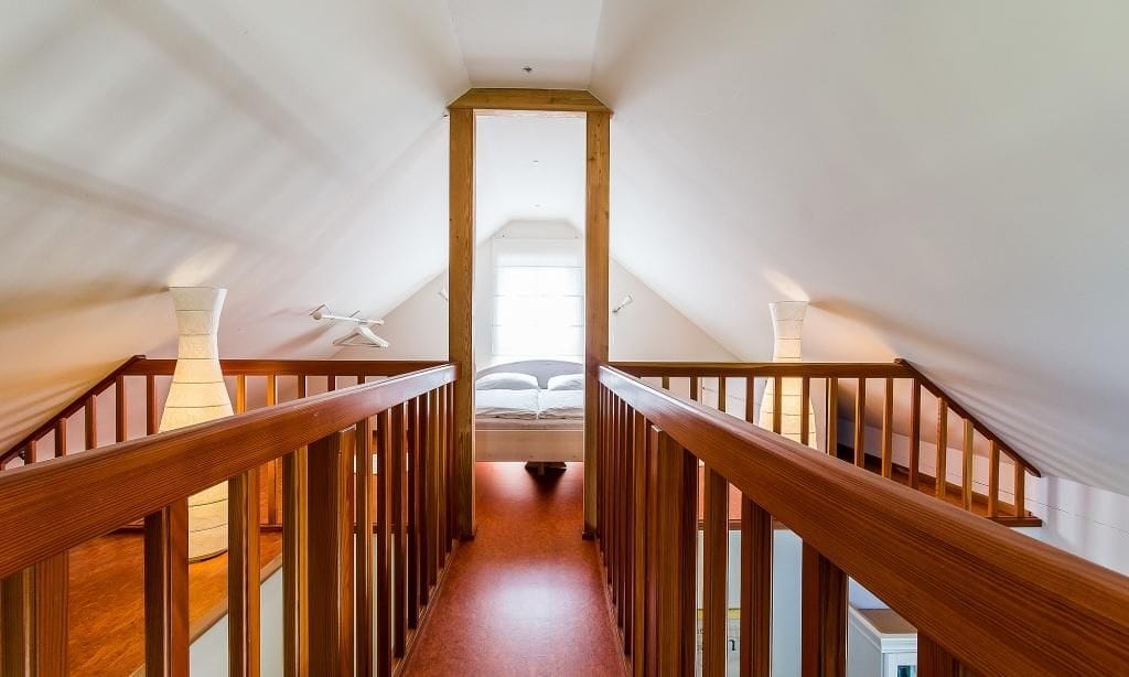 Dachgeschoss-Schlafzimmer mit Holzgeländer und Tageslicht