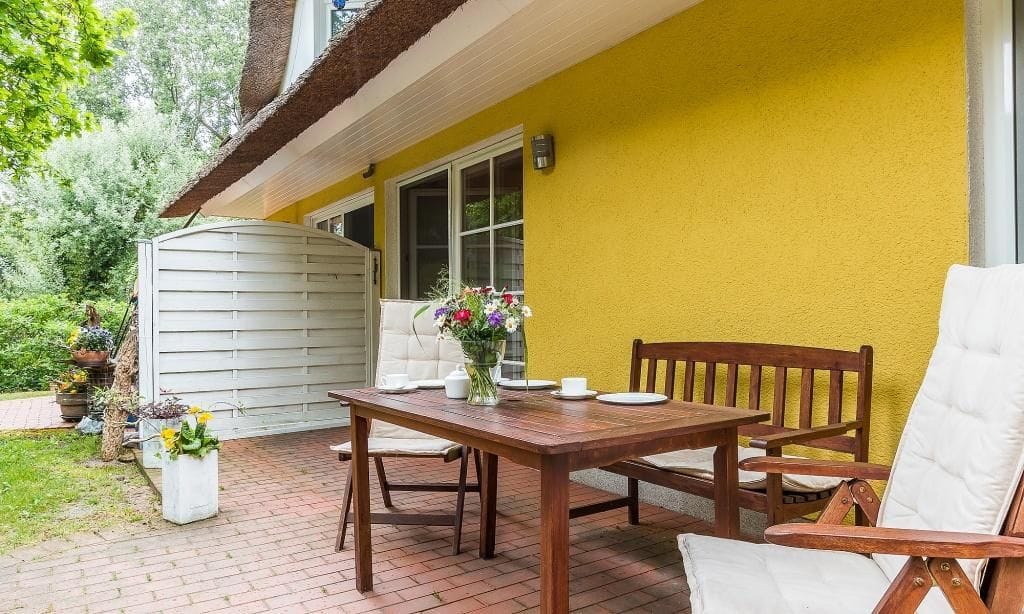 Einladende Terrasse mit Holztisch und Pflanzen