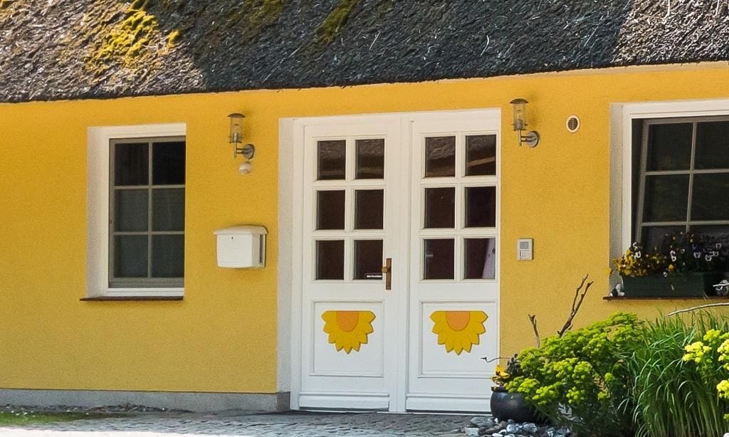 Eingang zu einem gelben Gebäude mit weißen Türen
