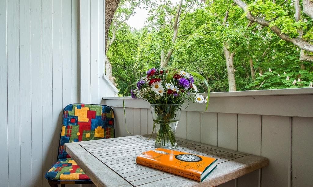 Balkon mit Tisch und buntem Stuhl