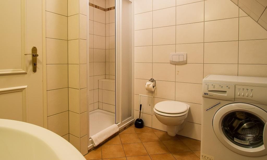 Badezimmer mit Dusche und Waschmaschine