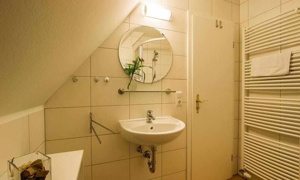 Kleines Badezimmer mit Waschbecken und Spiegel