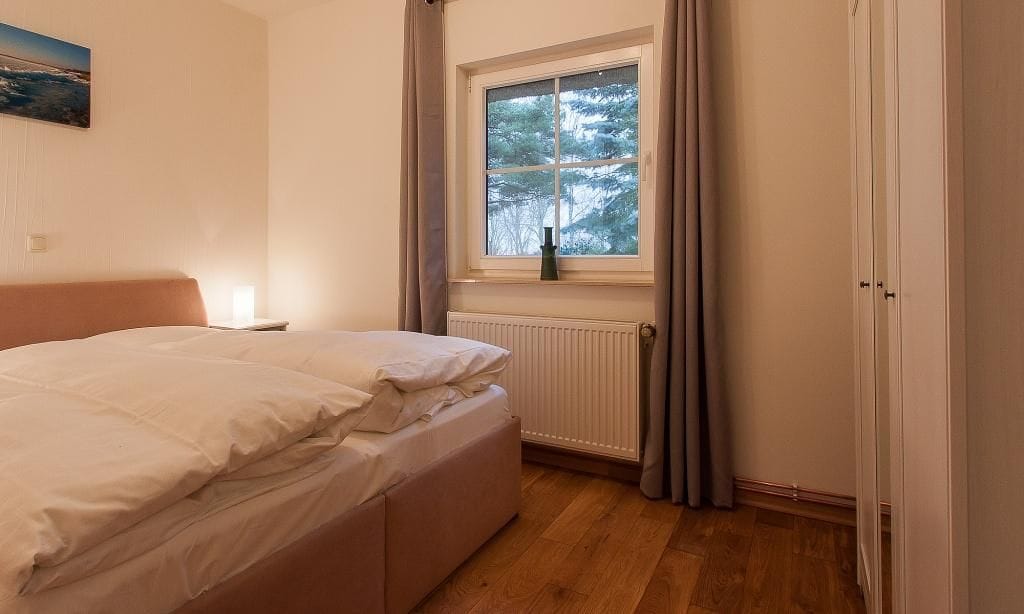 Schlafzimmer mit Doppelbett und Fenster