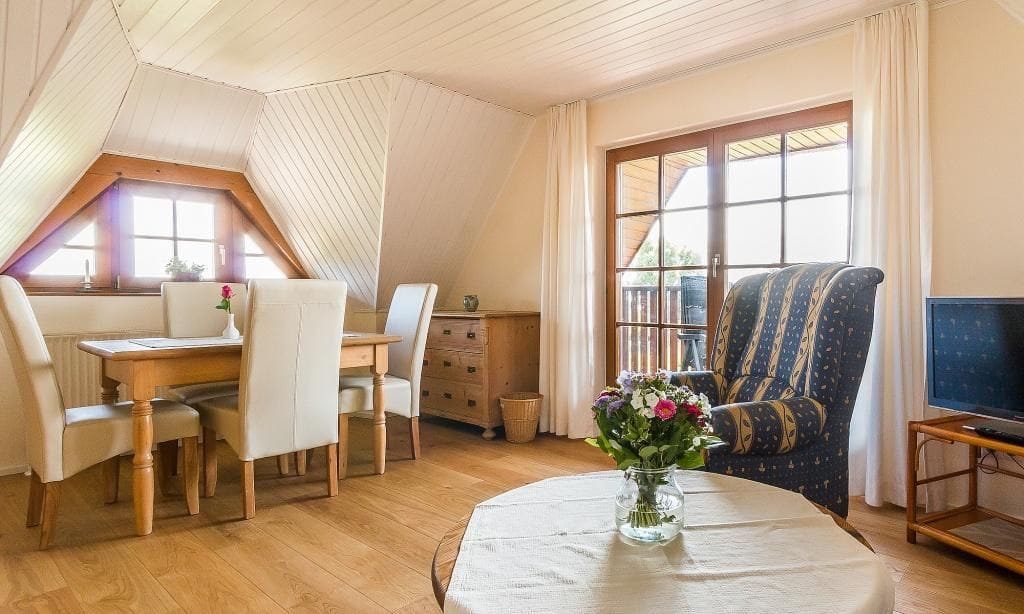 Gemütliches Wohnzimmer mit Esstisch und TV
