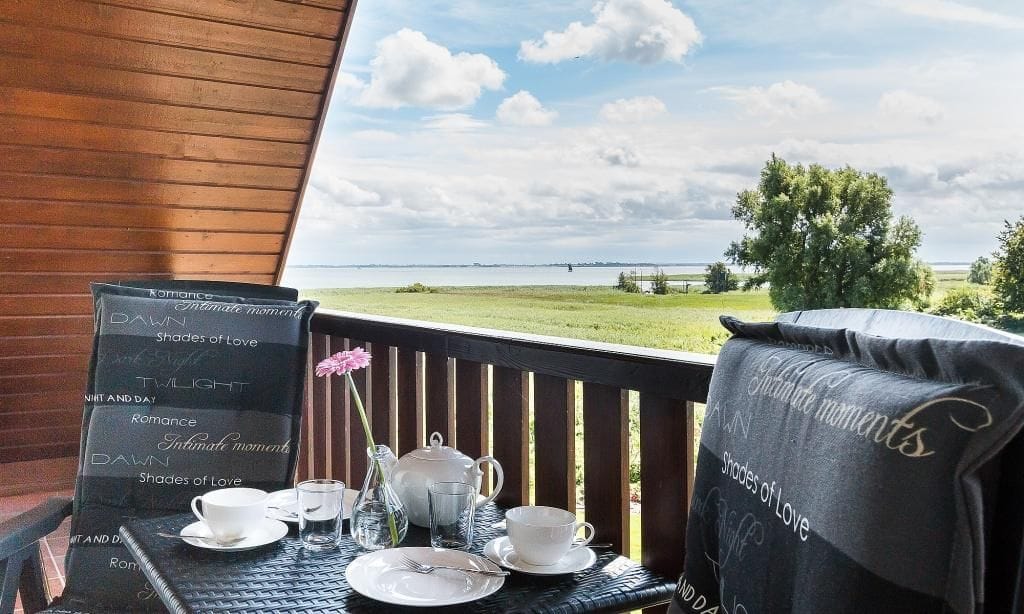 Balkon mit Tisch und Blick auf die Wiesen