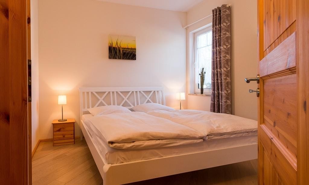 Helles Schlafzimmer mit Doppelbett und Nachttischen