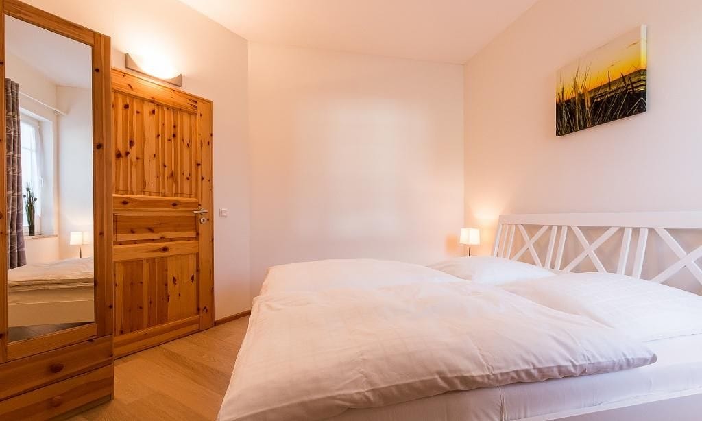 Helles Schlafzimmer mit Doppelbett und Holzdekor