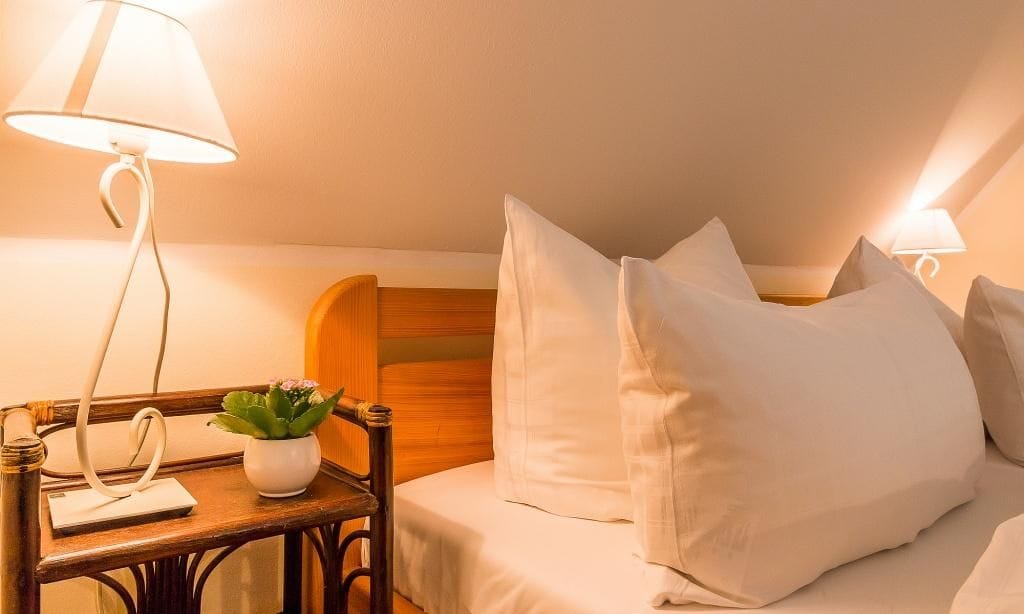 Helles Schlafzimmer mit Bett und Nachttisch.