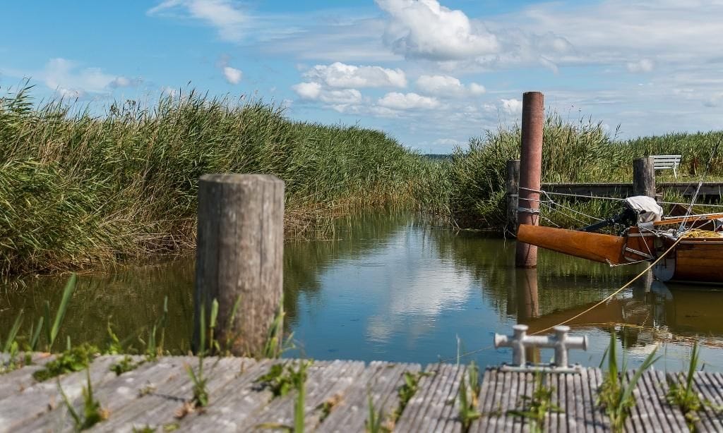 Ruhiger Wasserweg mit Holzsteg und Boot