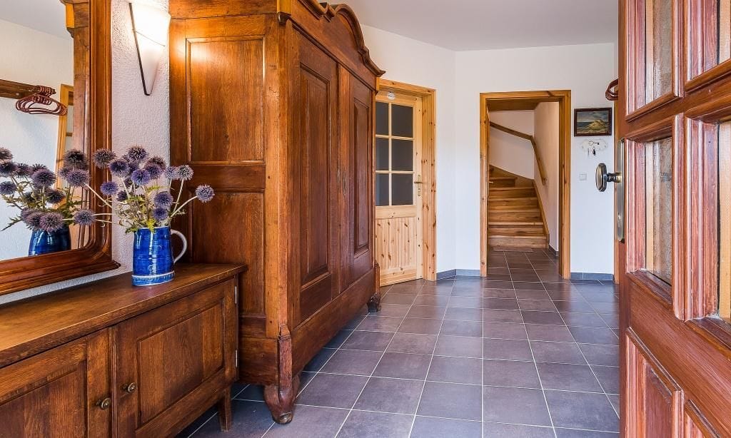 Eingangsbereich mit Holzschrank und Spiegel
