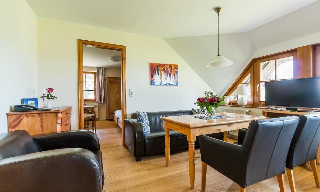 Gemütliches Wohnzimmer mit Esstisch und Fernseher