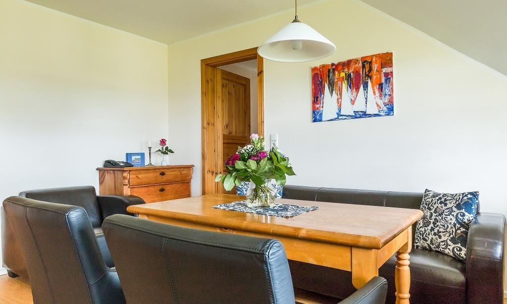 Helles Wohnzimmer mit Esstisch und Kunstwerk