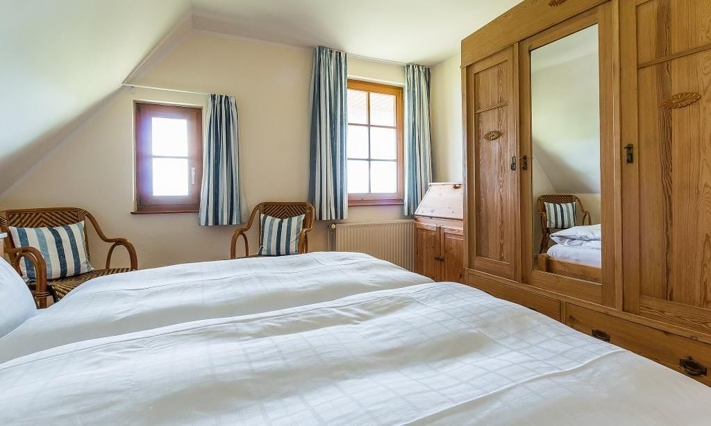 Doppelzimmer mit Holzschrank und Fenster