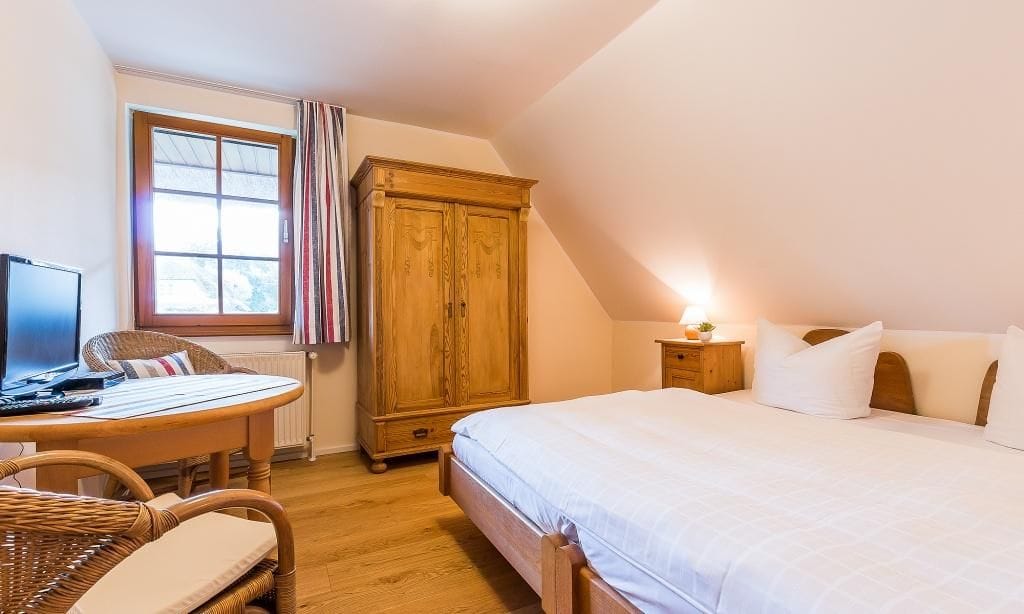 Schlafzimmer mit Doppelbett und Fernseher