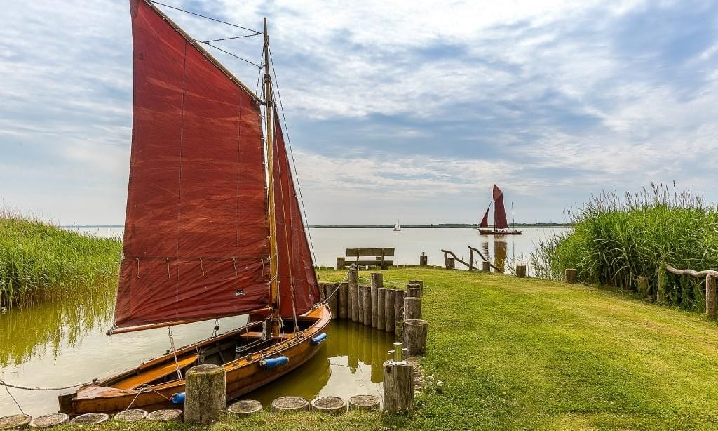 Landschaft mit Segelbooten am ruhigen Ufer